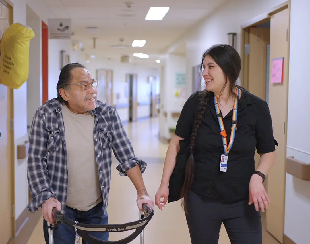 Nurse chatting with a patient in hospital corridor