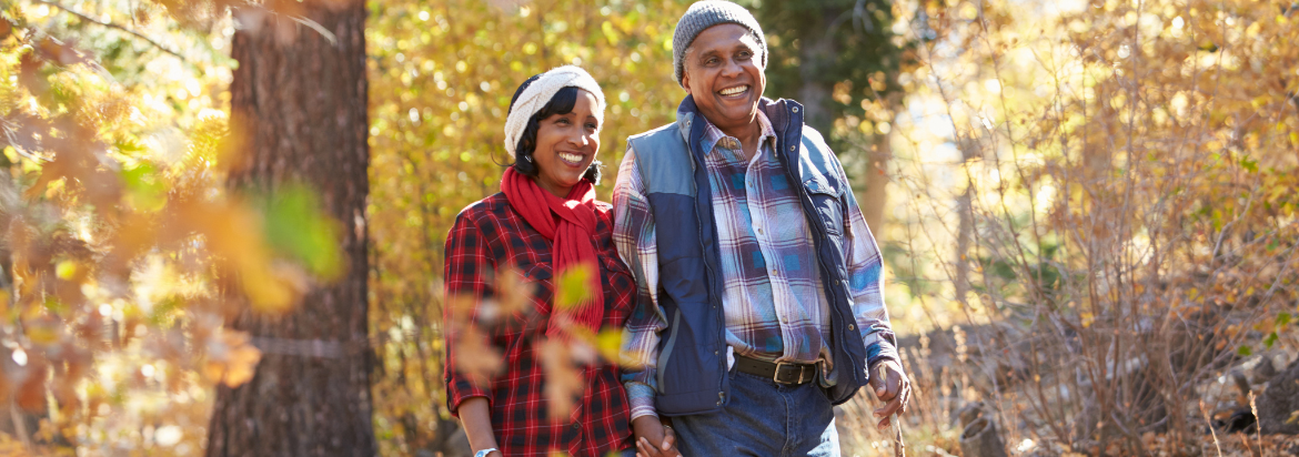 Senior female and male walking through a forest in autumn