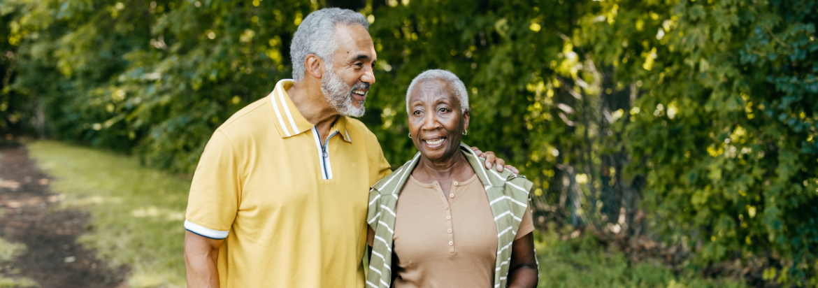 two seniors walking with their arms around each other