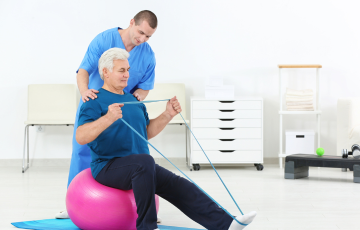 adult doing physical therapy with care aide